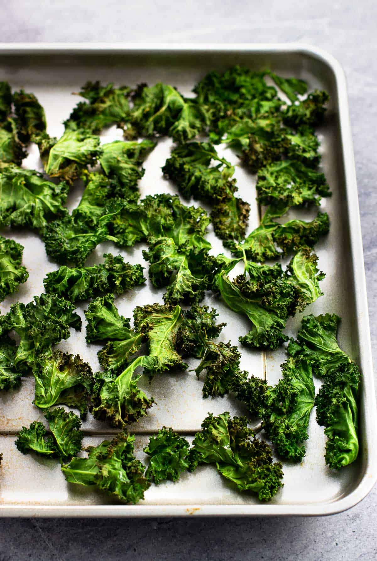 Air fryer kale chips on the metal air fryer tray.