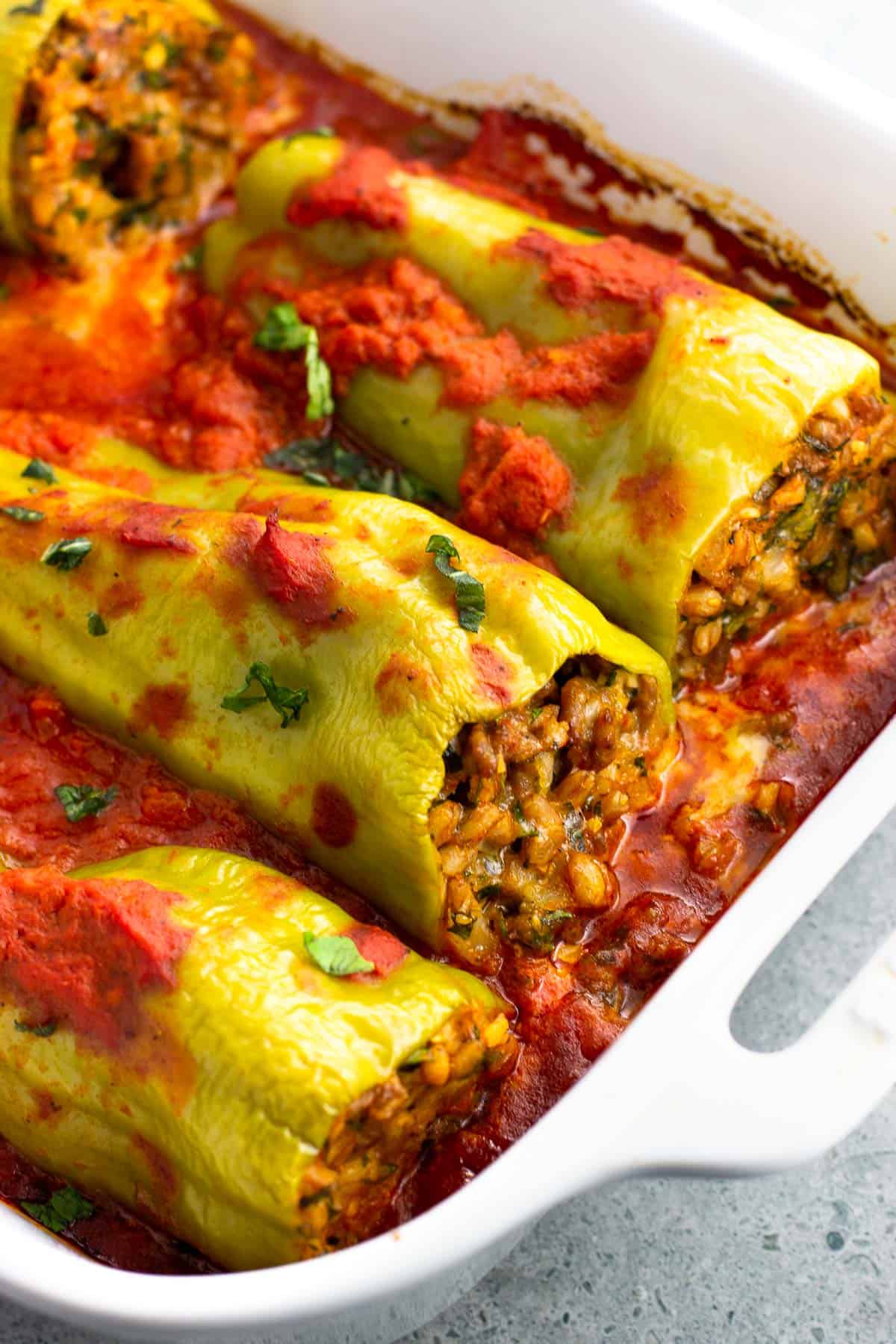 Stuffed cubanelle peppers in large dish after being baked.