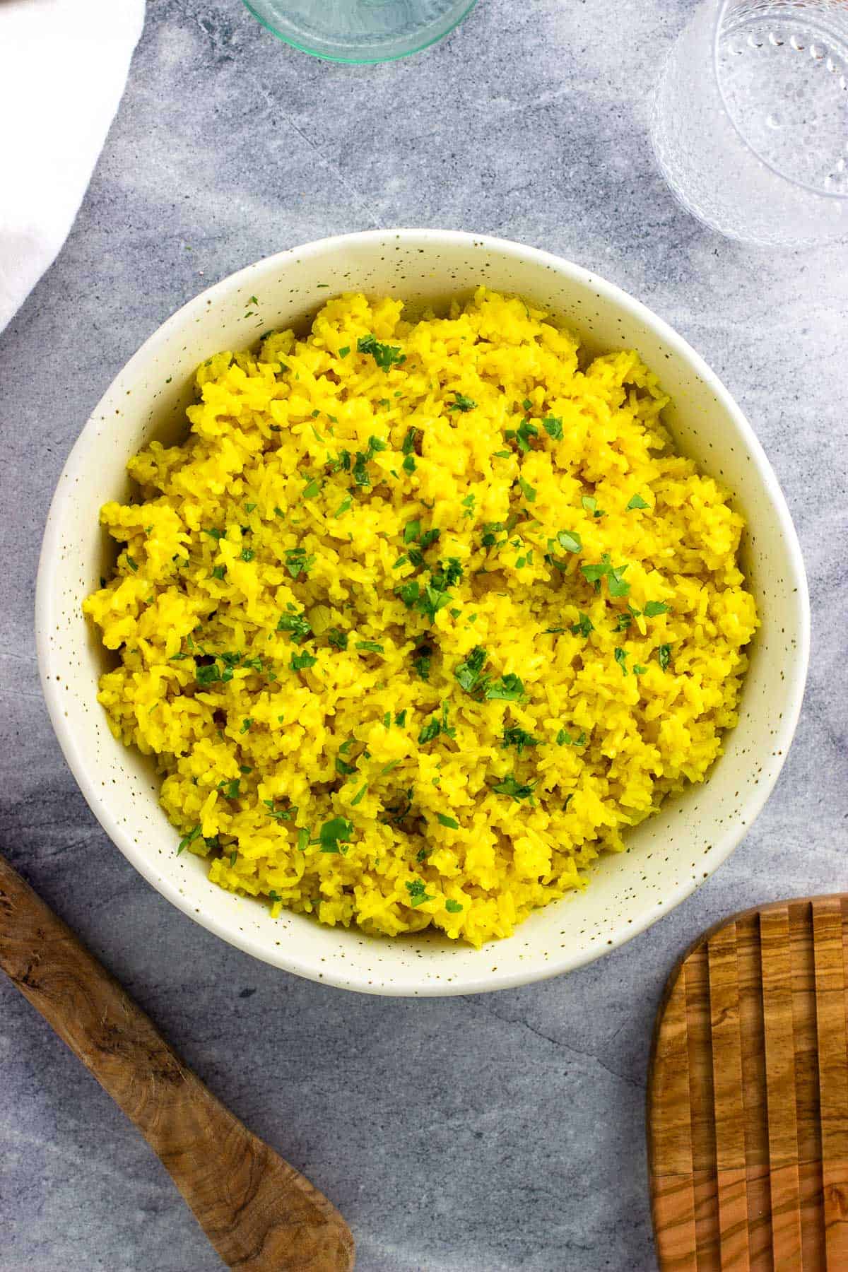 A ceramic bowl of rice garnished with chopped cilantro.