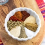 Herbs and spices that make up taco seasoning blend in a small bowl.