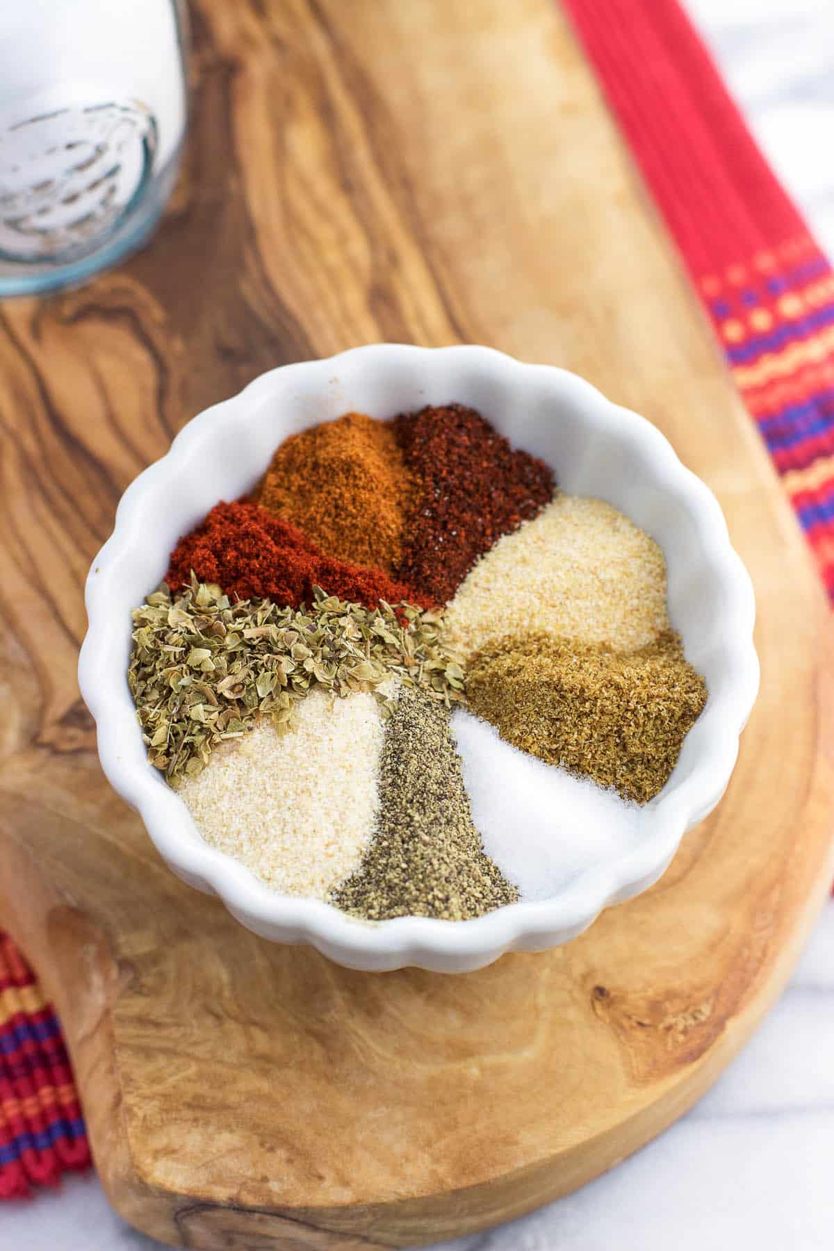 Herbs and spices that make up taco seasoning blend in a small bowl.