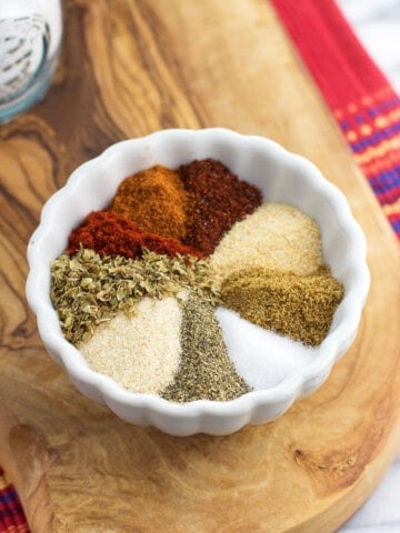 All of the taco seasoning ingredients poured into a bowl before mixing together.