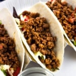 Three ground beef tacos in a holder.
