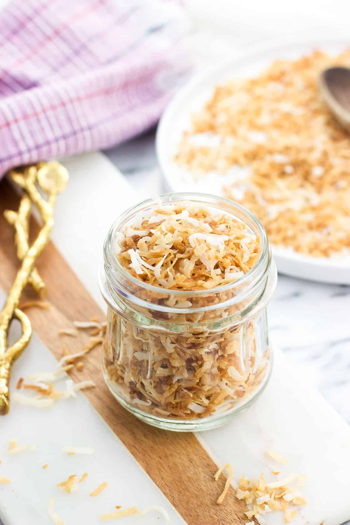 A glass jar filled with toasted coconut flakes.