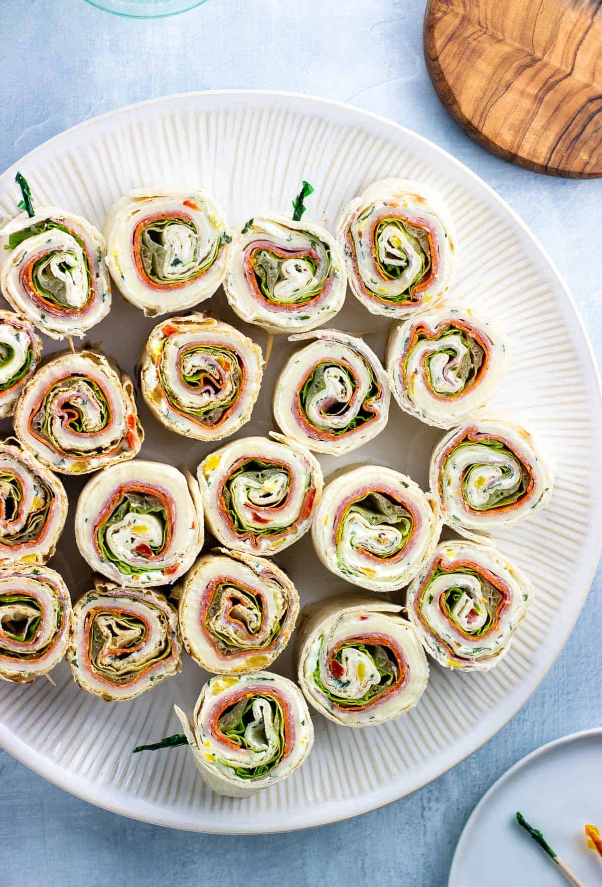 A large plate of Italian pinwheel sandwiches.