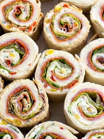 A large plate of Italian pinwheel sandwiches.