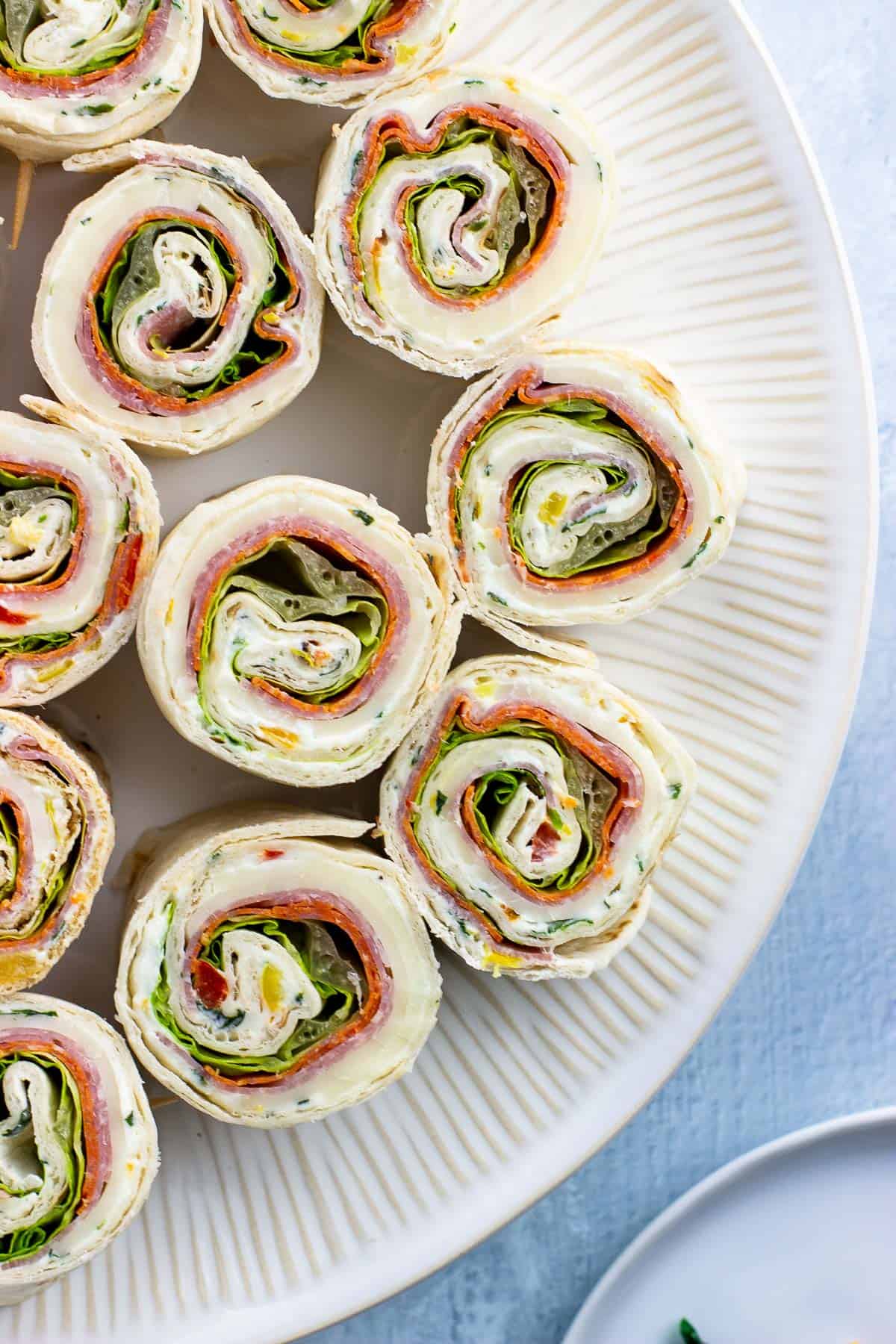 A large plate of Italian pinwheel sandwiches.