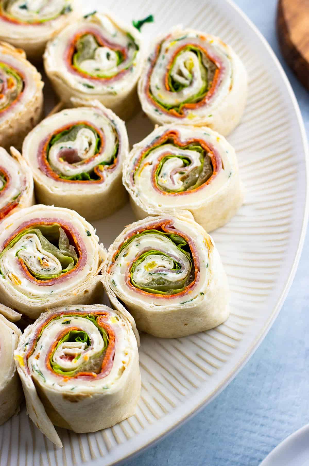 Provolone, salami, and pepperoni pinwheels on a plate.