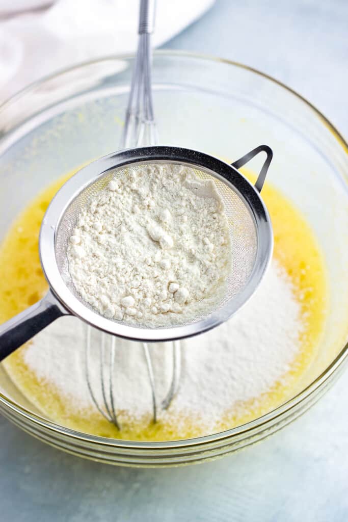 Flour being sifted into the bowl of filling ingredients.