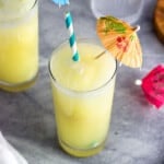 A pina colada mocktail in a glass with a straw and paper drink umbrella.