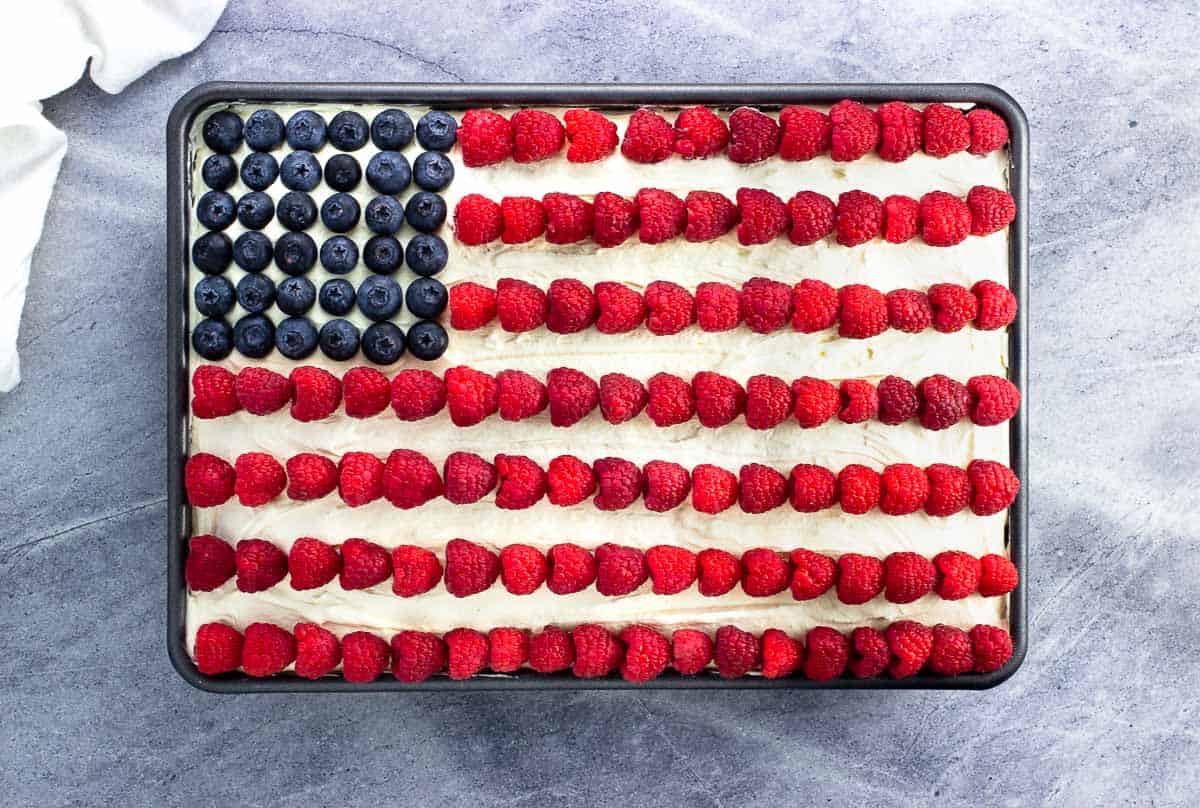 An American Flag cake design in blueberries and raspberries on ice cream cake.