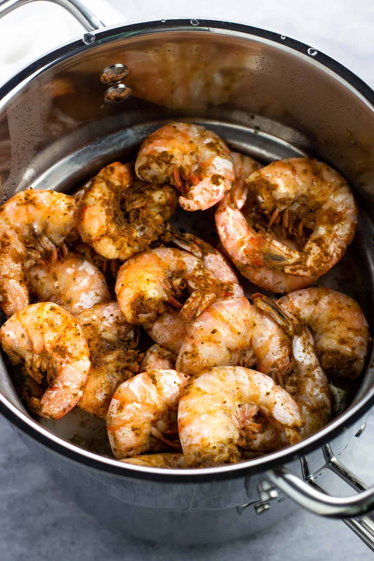 Extra-large steamed shrimp in a stainless steel steamer pot.