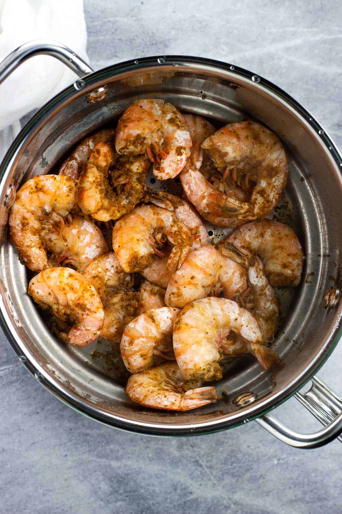 Steamed shrimp in the metal steamer insert of a pot.