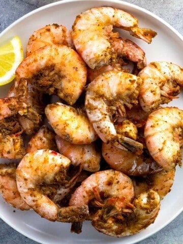 A plate of large steamed shrimp coated in Old Bay.