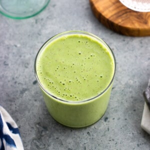 A pineapple matcha smoothie in a glass.