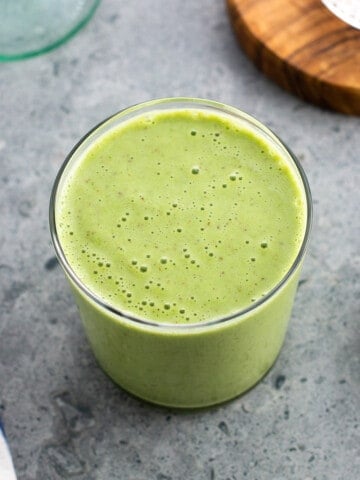 A pineapple matcha smoothie in a glass.