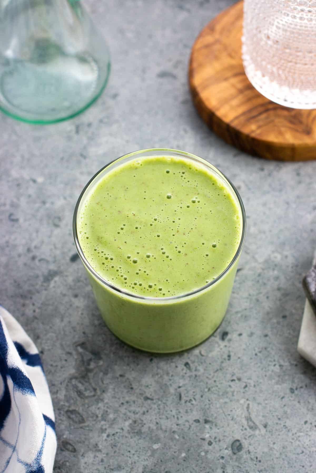 A pineapple matcha smoothie in a glass.