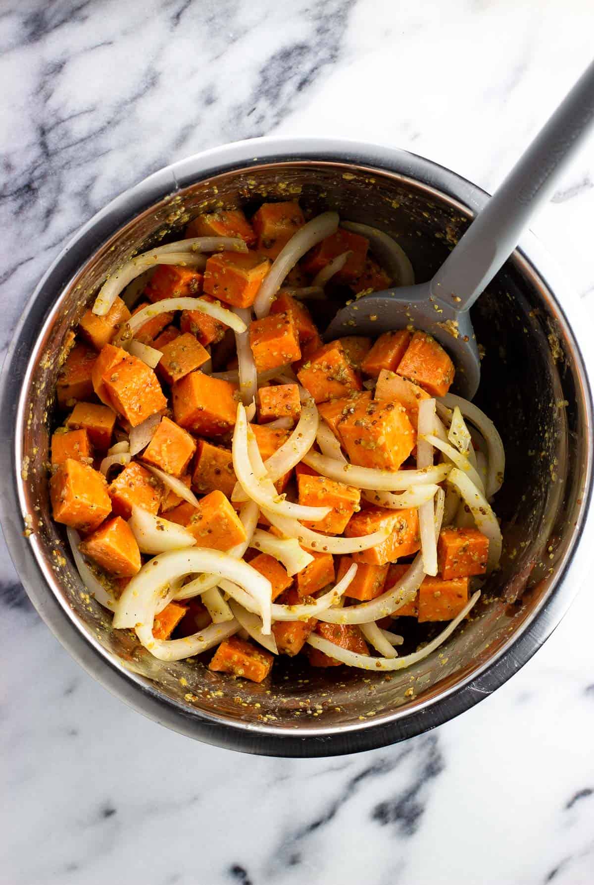 The sweet potatoes and onions mixed together in a bowl.