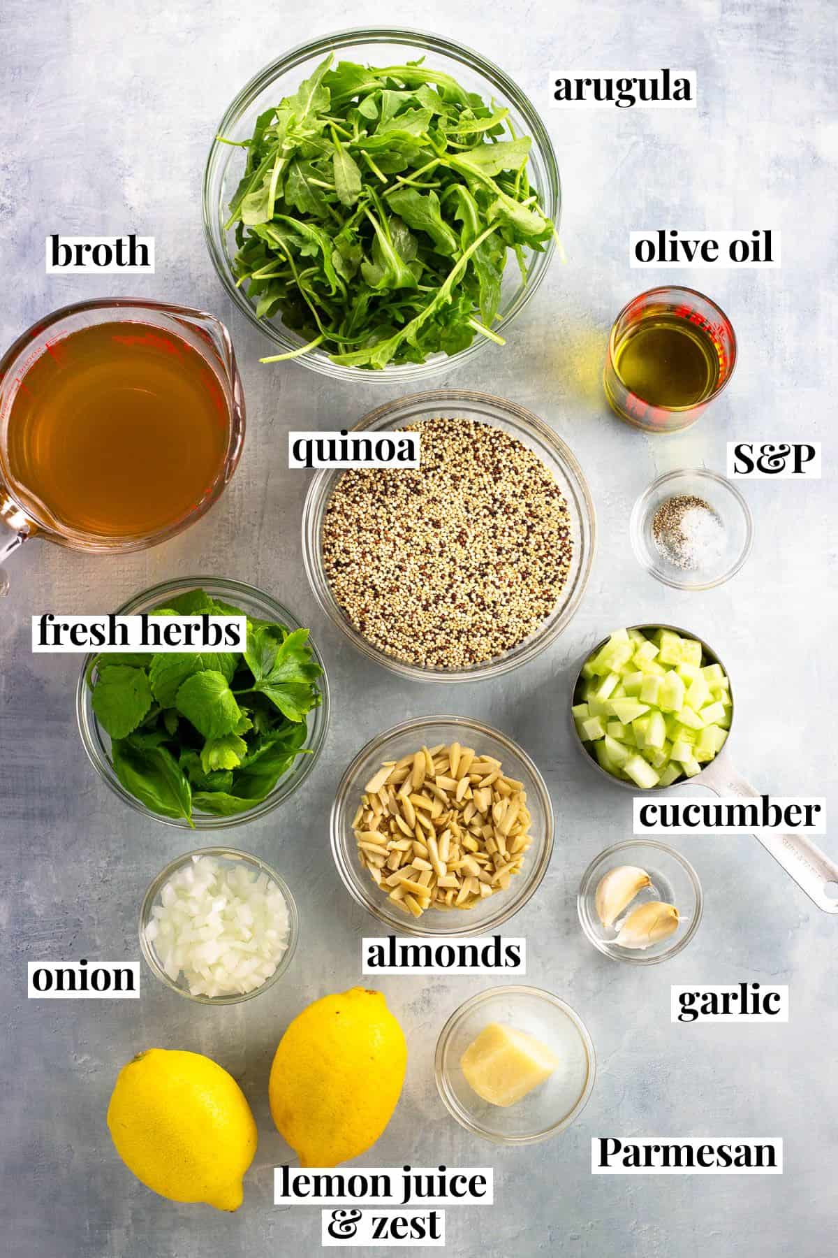 Labeled quinoa salad ingredients in separate containers.