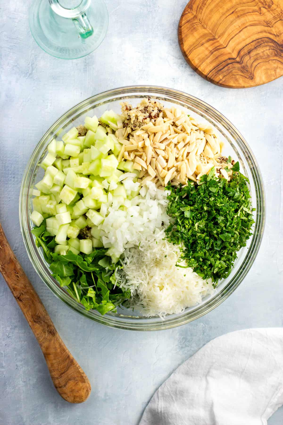 All quinoa salad ingredients except for the dressing added to a glass bowl.