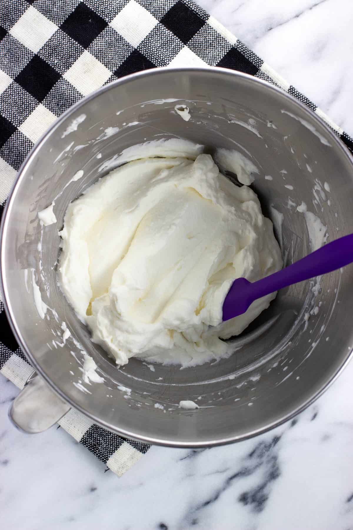 Fluffy stabilized whipped cream in a metal stand mixer bowl.