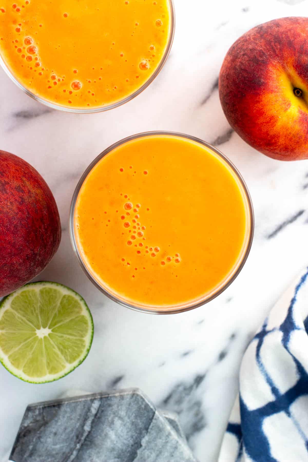 An overhead view of peach mango smoothies in short glasses.