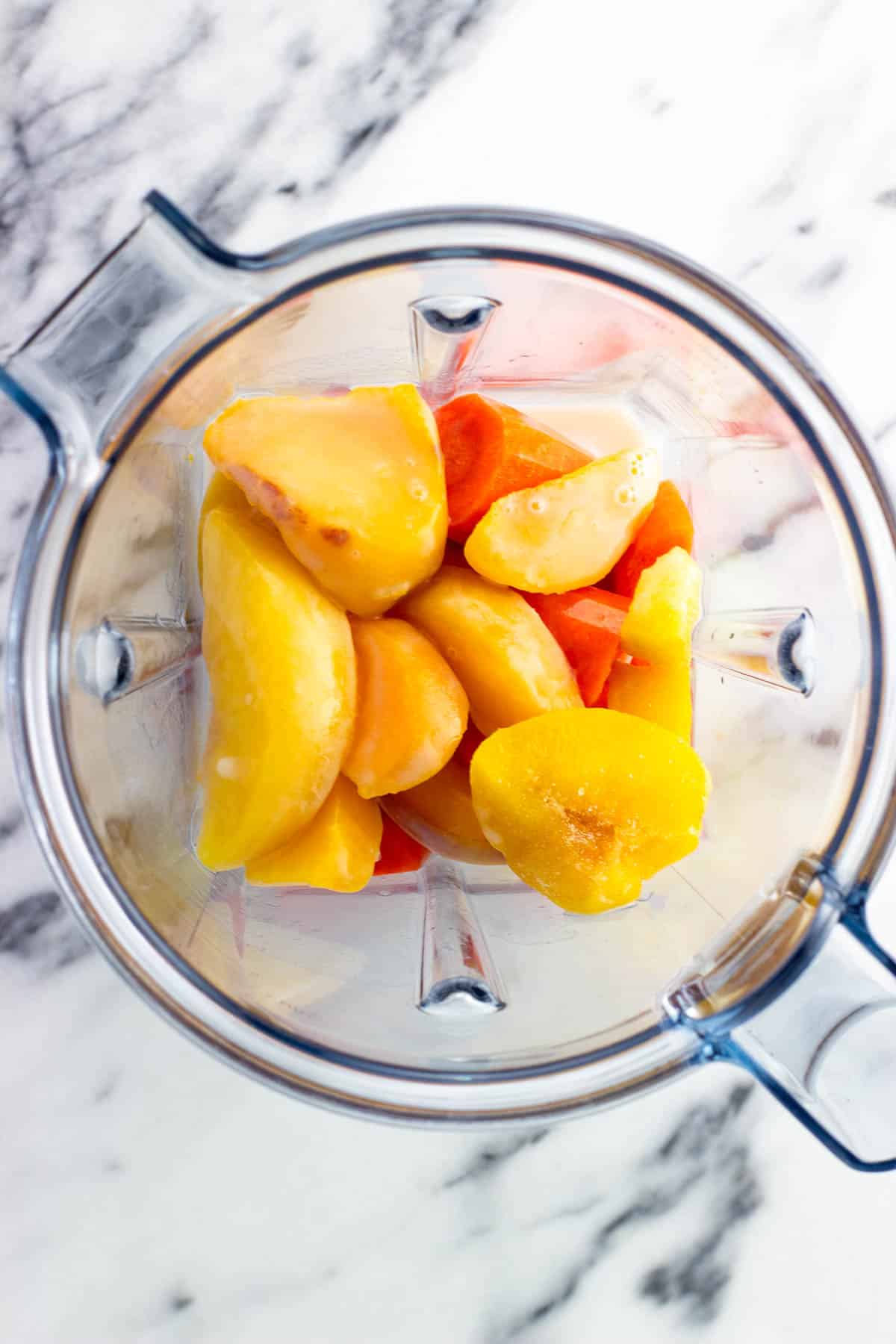 All of the smoothie ingredients added to a blender.