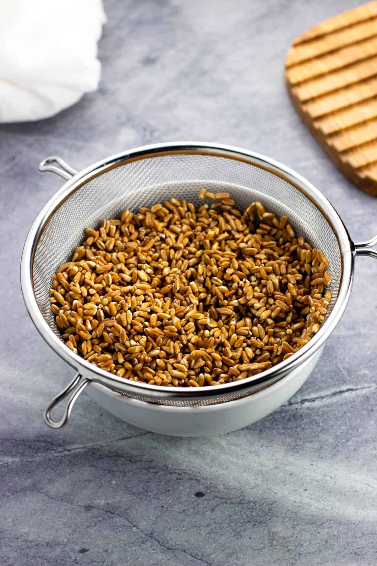 Rinsed dry farro in a large strainer.