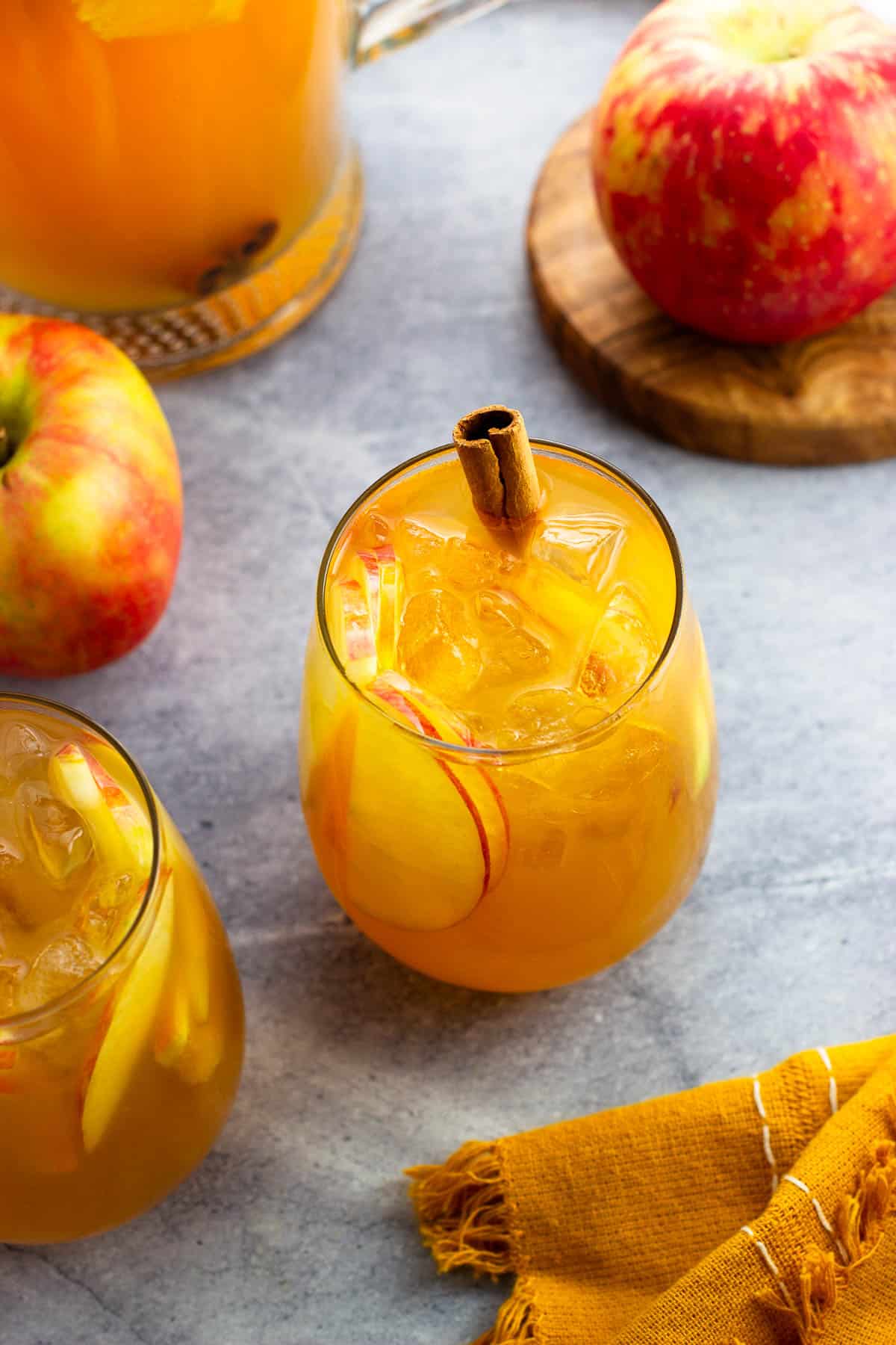 Glasses of apple cider sangria garnished with cinnamon sticks.