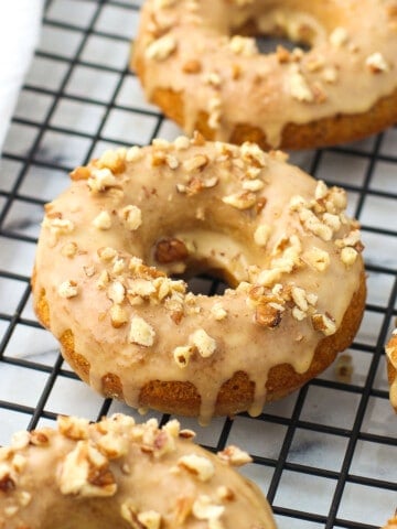 Baked pumpkin donuts on a wire rack.