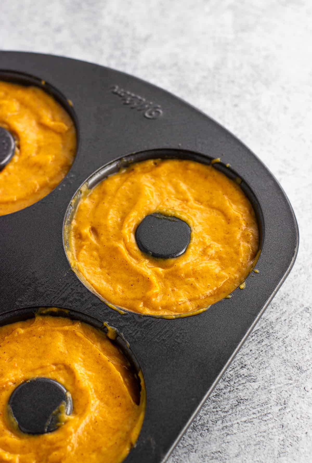 Pumpkin batter in the donut pan.