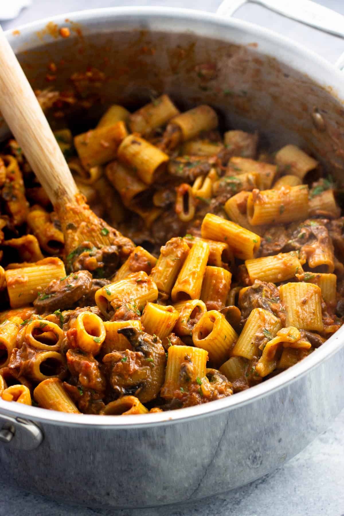 Steaming hot pasta alla boscaiola in a saucepan ready to serve.