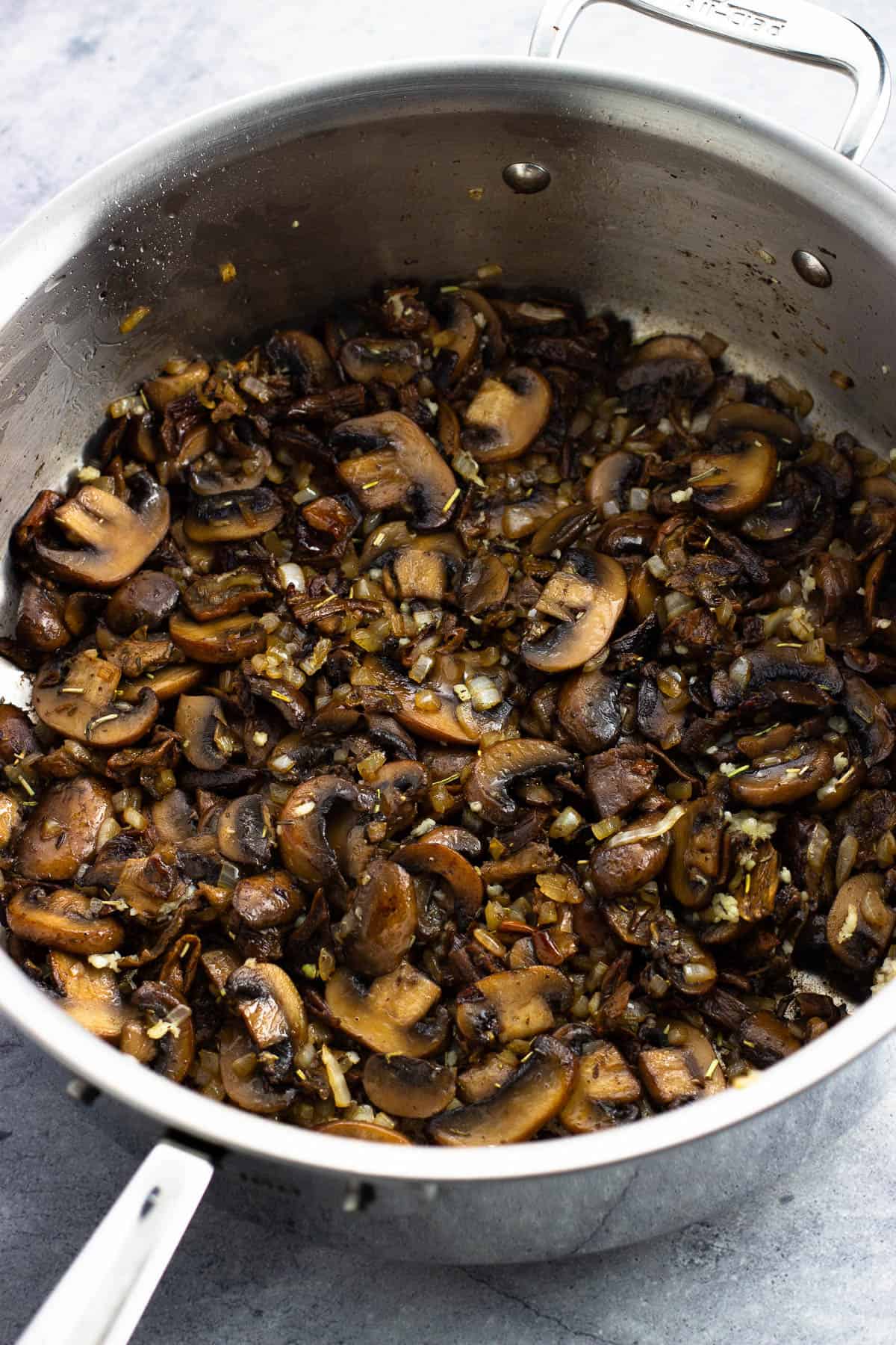 A pan of sautéing mushrooms, onion, and garlic.