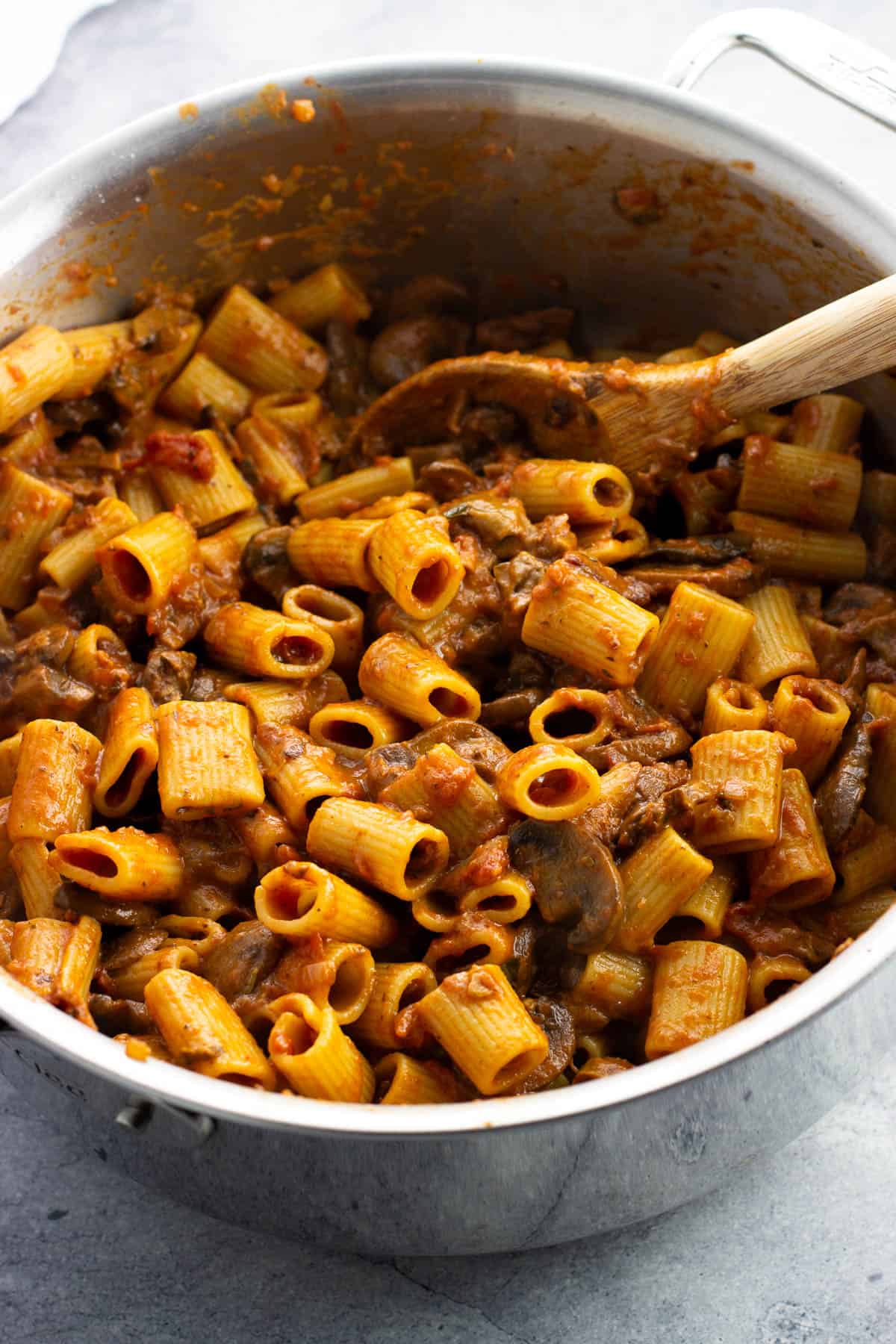 Cooked rigatoni tossed in the pan of boscaiola pasta sauce.