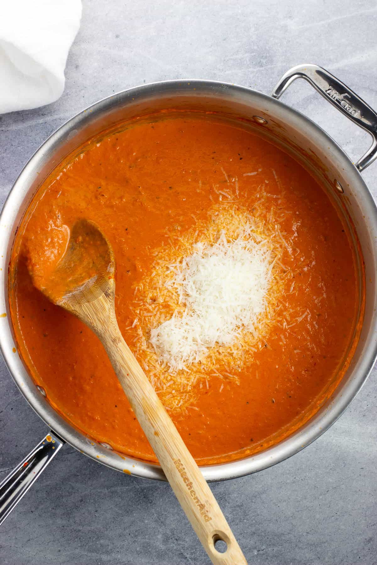 Cheese being stirred into the spicy vodka sauce.