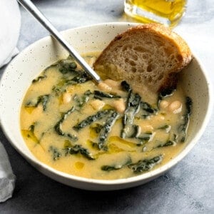 A bowl of white bean and potato soup served with bread.