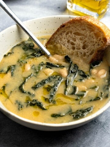 A bowl of white bean and potato soup served with bread.