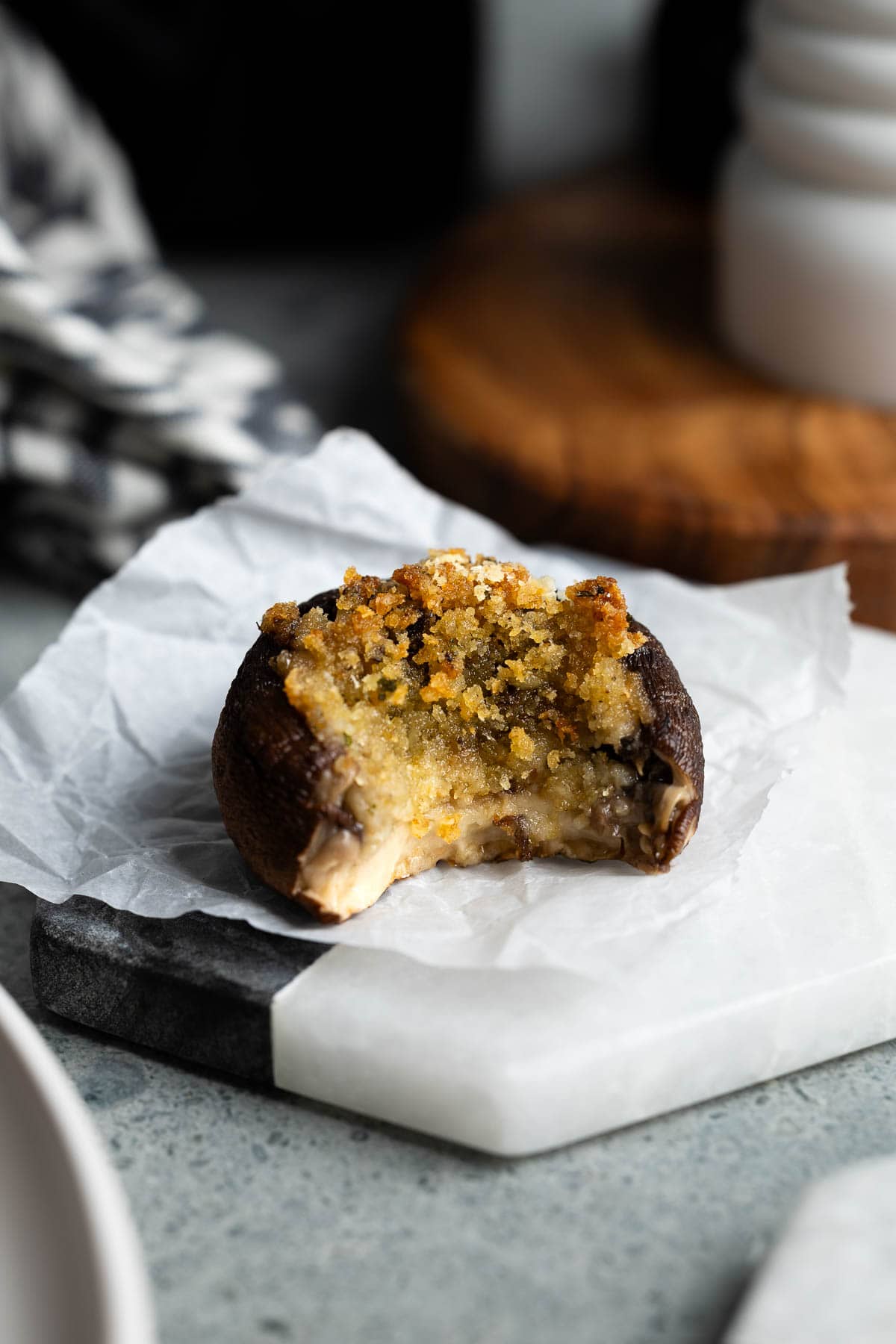 One stuffed mushroom with a bite taken out of it.