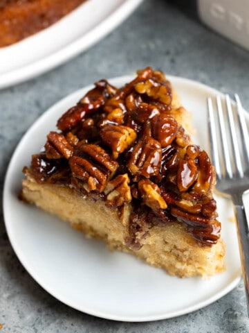 A slice of pecan upside down cake on a small dessert plate.