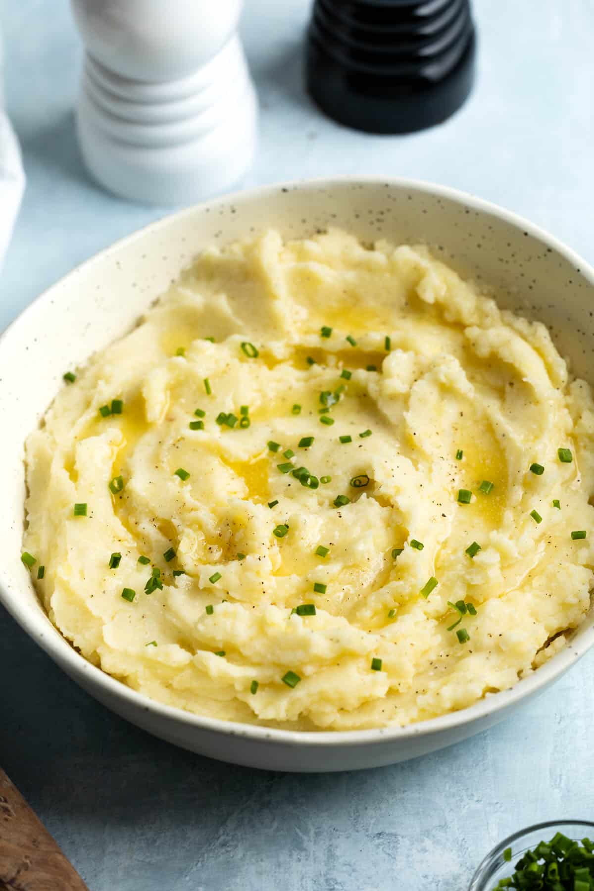 A shallow serving bowl of sour cream mashed potatoes.