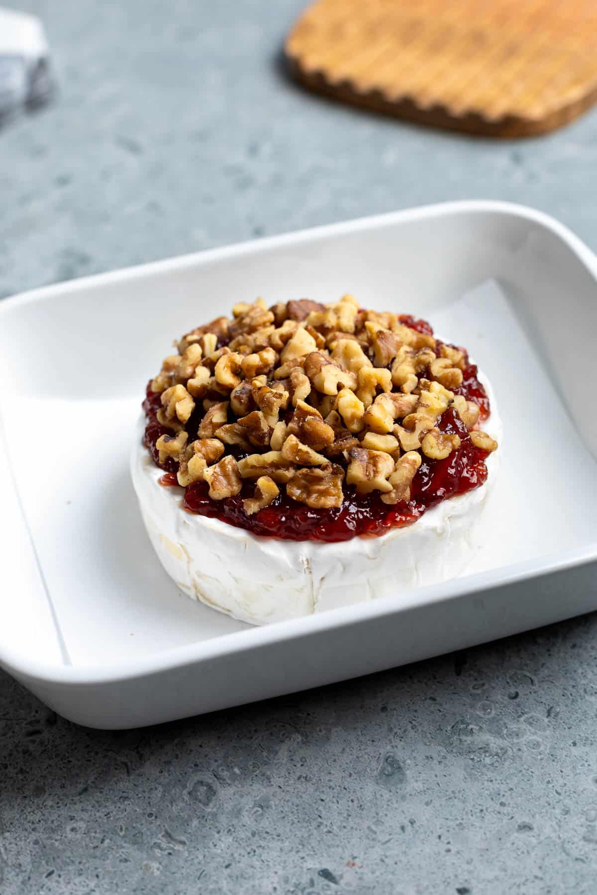 Brie topped with jam and nuts before baking.