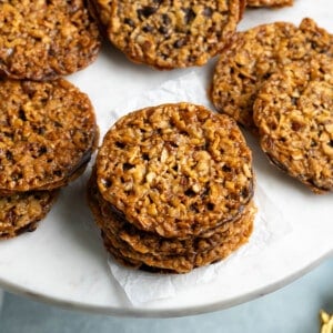 Florentine cookies pressed together with chocolate on a serving board.