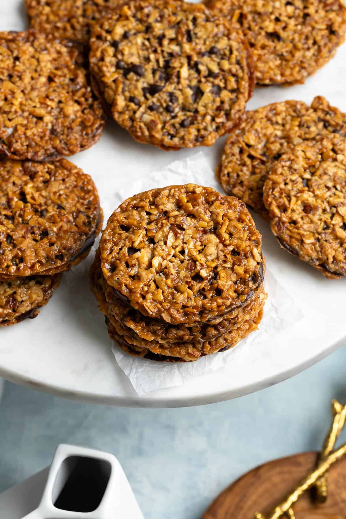 Florentine cookies pressed together with chocolate on a serving board.