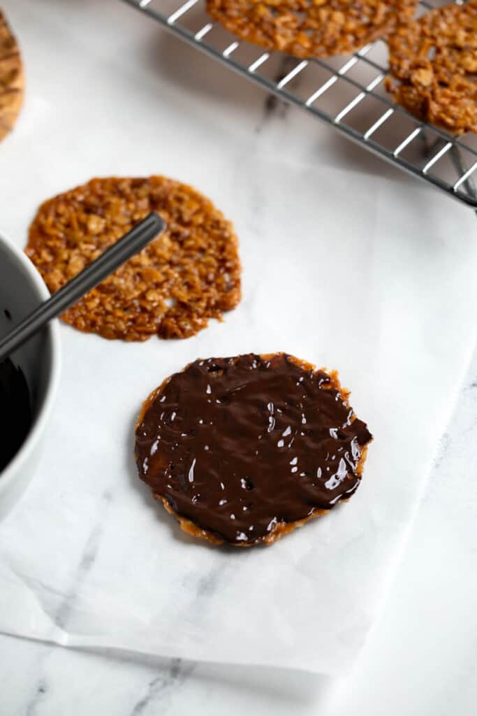 Chocolate slathered onto a florentine cookie.