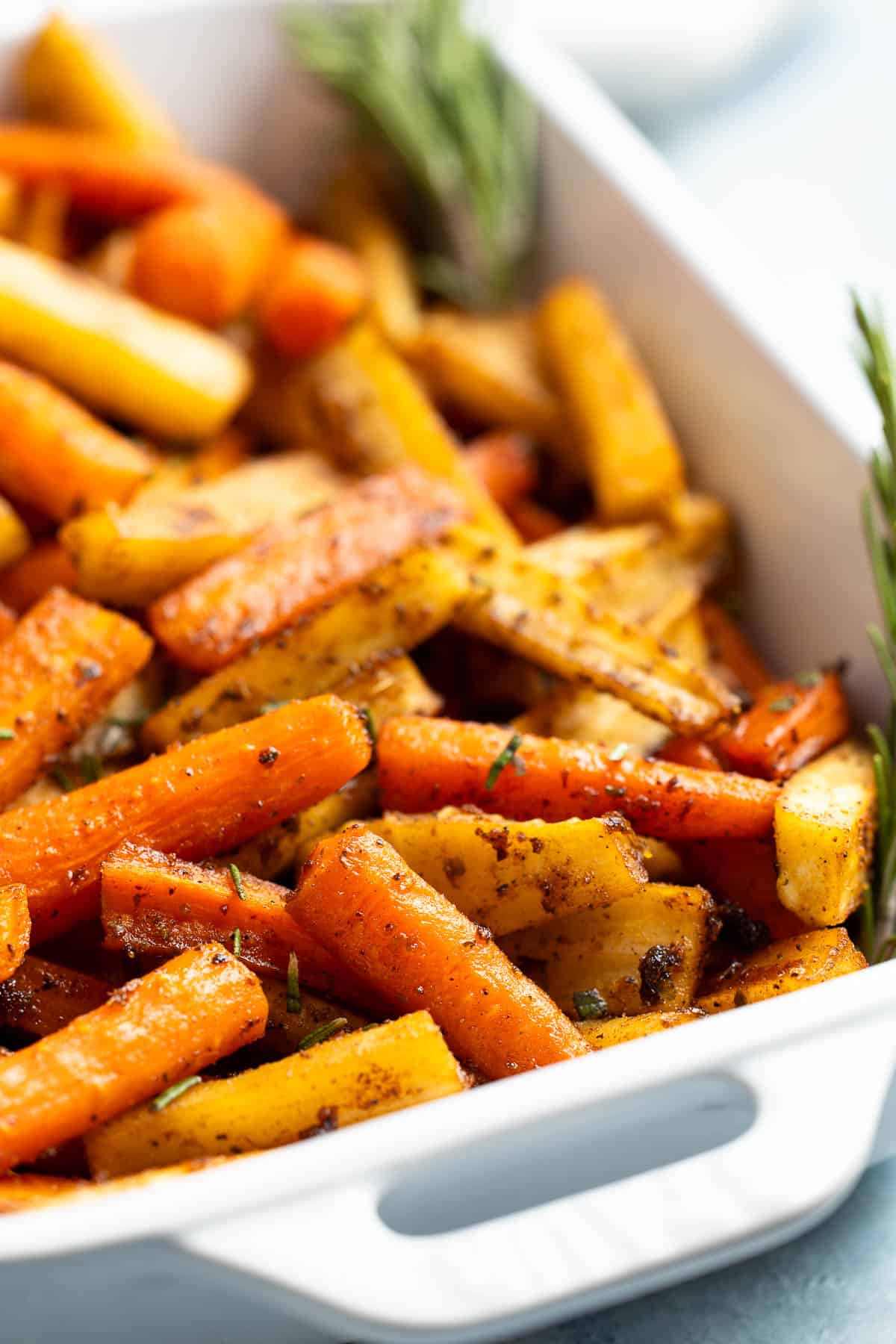 A serving dish of roasted carrots and parsnips.