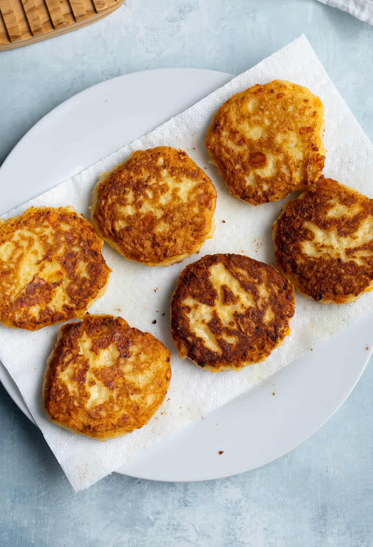 The patties draining on a paper towel lined plate.