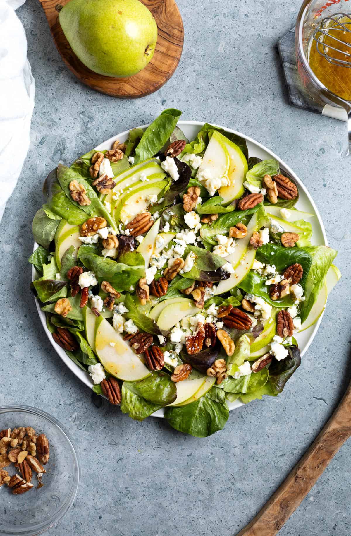 Pear gorgonzola salad with nuts on a serving plate.