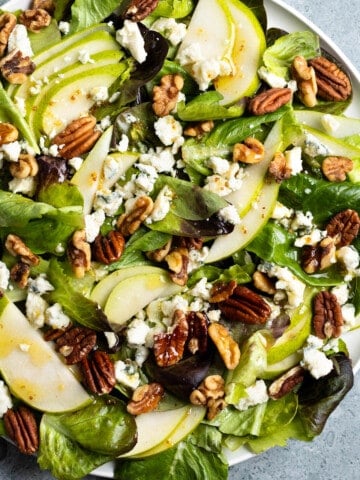 Pear slices, crumbled Gorgonzola, and toasted nuts on a mixed greens salad.