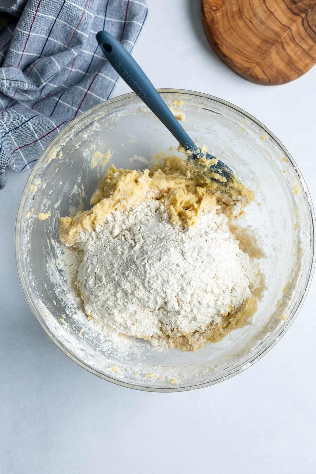Flour being added to the bowl of cookie dough.