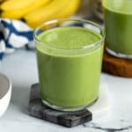 Collard greens smoothie in a short glass.